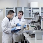 Researchers discuss work at laboratory bench