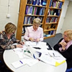 Three researchers discussing a domestic violence research project