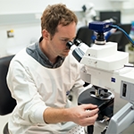 Researcher working at a microscope from Queensland Brain Institute