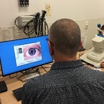 Researcher looking at a magnified eye on a screen